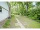Spacious backyard with a stone pathway leading to a swing, surrounded by mature trees and greenery at 2807 Westleigh Dr, Indianapolis, IN 46268