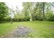 Large backyard featuring a shed, mature trees, a fire pit, and lush green space at 2807 Westleigh Dr, Indianapolis, IN 46268