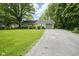 Inviting single-story home featuring a lush green lawn, mature trees, and a paved driveway at 2807 Westleigh Dr, Indianapolis, IN 46268