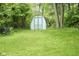Backyard shed featuring a white and turquoise color scheme surrounded by lush greenery at 2807 Westleigh Dr, Indianapolis, IN 46268