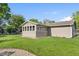 Spacious yard featuring green grass, a small storage shed, and an enclosed patio at 2810 Bittersweet Blvd, Columbus, IN 47203