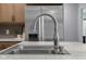 Close-up of the kitchen sink with modern faucet and stainless steel appliances in the background at 2810 Bittersweet Blvd, Columbus, IN 47203
