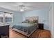 Bright main bedroom featuring queen-size bed, ceiling fan, and wood flooring at 2810 Bittersweet Blvd, Columbus, IN 47203