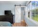 Bright bedroom with barn door to en suite bath and wood-look flooring at 2810 Bittersweet Blvd, Columbus, IN 47203