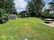 Sprawling backyard offers lush green space with mature trees and a storage shed, ideal for outdoor activities at 3023 Fairlawn Dr, Columbus, IN 47203