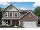 Charming two-story home featuring a brick and siding exterior with a two-car garage and well-maintained landscaping at 310 Atlas Dr, Lebanon, IN 46052