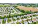 Spacious neighborhood is shown from above, featuring mature trees, and homes with well-kept yards next to open fields at 3221 Holt St, Whiteland, IN 46184