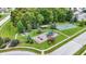 Overhead view of neighborhood park showcasing playground, basketball court, green lawns, and mature trees for Gathering enjoyment at 3221 Holt St, Whiteland, IN 46184