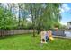 Backyard view features a play structure, mature trees, and a fenced yard at 3221 Holt St, Whiteland, IN 46184
