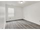 Well-lit bedroom featuring modern gray vinyl floors, a window, and fresh white walls at 3222 Enclave Ln, Greenwood, IN 46143