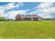 Rear view of a well-maintained brick home featuring a lush green lawn and a shed at 3319 E 700 N, Whiteland, IN 46184