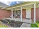 Charming front porch with chairs and a welcoming entrance, enhancing the curb appeal of this brick home at 3319 E 700 N, Whiteland, IN 46184