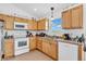 Bright kitchen features wooden cabinetry, white appliances, and ample counter space for cooking at 3319 E 700 N, Whiteland, IN 46184