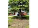 Red brick home with a large tree in the front yard, offering shade and curb appeal at 3633 Tiffany Dr, Indianapolis, IN 46226