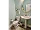 Powder room features a pedestal sink, oval mirror, and wood-look floors at 3691 Talmine Ln, Bargersville, IN 46106