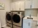 Modern laundry room with new front load washer and dryer, plus built-in cabinets at 3691 Talmine Ln, Bargersville, IN 46106