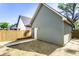 Backyard view featuring a wooden fence, grass, side door, and a concrete path at 39 N Walcott St, Indianapolis, IN 46201