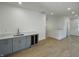 A stylish bar area with grey cabinets, quartz countertops, a sink, and a wine cooler is featured in this contemporary living space at 39 N Walcott St, Indianapolis, IN 46201