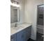 Modern bathroom with gray vanity, white countertop, and a view into the tiled shower and tub area at 39 N Walcott St, Indianapolis, IN 46201