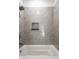 Close-up of stylish bathroom with gray tiled walls, recessed shower niche, and soaking tub at 39 N Walcott St, Indianapolis, IN 46201