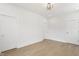 Spacious bedroom with light hardwood floors, modern light fixture, and three doors at 39 N Walcott St, Indianapolis, IN 46201
