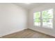 Bright bedroom featuring hardwood floors and natural light from two windows at 39 N Walcott St, Indianapolis, IN 46201