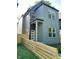Two-story home with green siding, a modern front door, and a well-maintained lawn and wooden fence at 39 N Walcott St, Indianapolis, IN 46201