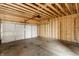 Spacious unfinished garage with wood framing, concrete floor, and an automatic garage door at 39 N Walcott St, Indianapolis, IN 46201