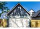 View of a detached garage with a white garage door and light fixtures at 39 N Walcott St, Indianapolis, IN 46201