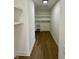 Walk-in closet with wood flooring, open shelving, and modern lighting providing storage for all your wardrobe needs at 39 N Walcott St, Indianapolis, IN 46201