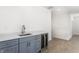 Finished basement wet bar with grey cabinets and wine refrigerator at 39 N Walcott St, Indianapolis, IN 46201