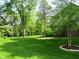 Lush backyard with manicured lawn and mature trees, providing privacy and a park-like setting at 4037 Oakleaf Dr, Zionsville, IN 46077