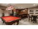 Finished basement bar with a pool table, bar seating, and glass door cabinets at 4037 Oakleaf Dr, Zionsville, IN 46077