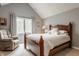 Bedroom with vaulted ceiling, wood frame bed, and a comfortable sitting chair at 4037 Oakleaf Dr, Zionsville, IN 46077