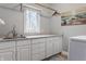 Well-lit laundry room with white cabinets, a sink, and a hanging rack for clothes at 4037 Oakleaf Dr, Zionsville, IN 46077