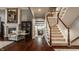 Cozy living room with fireplace, elegant staircase, and hardwood floors at 4037 Oakleaf Dr, Zionsville, IN 46077