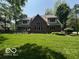 Rear exterior of home showing a large deck, spacious backyard, and traditional brick architecture at 4037 Oakleaf Dr, Zionsville, IN 46077