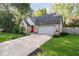 Brick and siding home featuring a red front door, two-car garage, a large concrete driveway and well-manicured lawn at 410 Wood Hollow Ct, Westfield, IN 46074