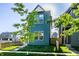 Contemporary home with a bright blue facade, enhanced by verdant landscaping and clear blue skies at 43 N Walcott St, Indianapolis, IN 46201