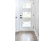 Elegant white front door with glass inserts, offering a peek into the home's interior and wood floors at 43 N Walcott St, Indianapolis, IN 46201