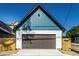 The garage is a blend of teal and white siding, crowned by a black roof at 43 N Walcott St, Indianapolis, IN 46201