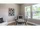 Bright home office with a glass desk, comfortable seating, and large windows overlooking the neighborhood at 43 N Walcott St, Indianapolis, IN 46201