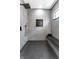 Modern shower with hexagon tile floor, gray wall tile, rainfall showerhead, and bench at 43 N Walcott St, Indianapolis, IN 46201