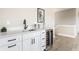 Close-up of wet bar with stainless steel wine fridge, black fixtures, and white cabinets at 43 N Walcott St, Indianapolis, IN 46201