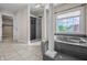 This bathroom features a tub with pillars, a glass shower and a window allowing plenty of natural light at 4368 W Eagle Trce, New Palestine, IN 46163