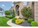 Charming brick home exterior with an arched entryway, lush landscaping, and a well-manicured lawn at 4368 W Eagle Trce, New Palestine, IN 46163