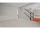 Spacious carpeted living room featuring a staircase with wood trim, offering a view of other rooms at 4368 W Eagle Trce, New Palestine, IN 46163