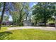 A long yard with green grass, a 2-car garage, with a partial swing set and lots of trees at 4809 Allisonville Rd, Indianapolis, IN 46205