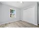 This bedroom features light gray walls, a closet, updated flooring, and a window that lets in natural light at 4809 Allisonville Rd, Indianapolis, IN 46205