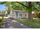 Cozy home featuring light gray siding, an inviting entryway, and a mature tree shading the property at 4809 Allisonville Rd, Indianapolis, IN 46205
